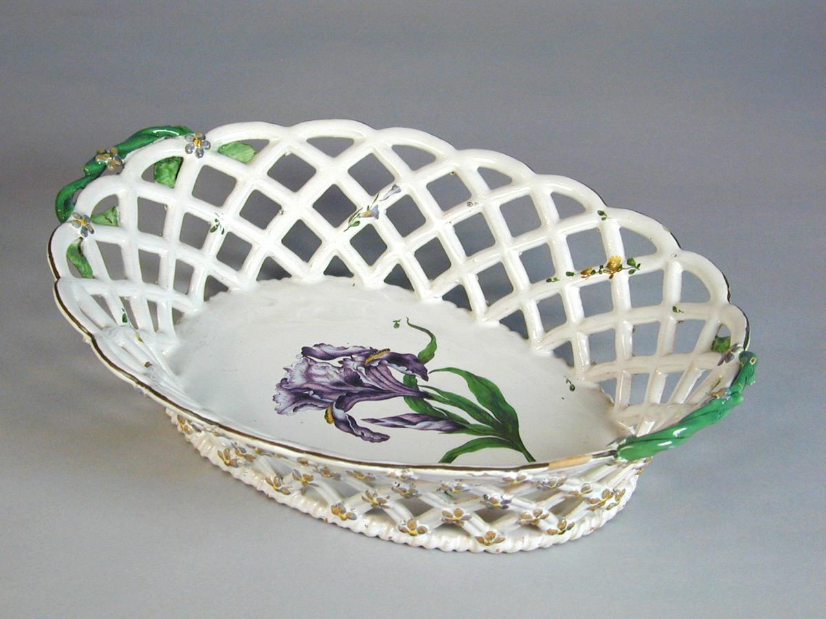 Strasbourg oval faience basket finely painted with a botanical specimen, c.1770.