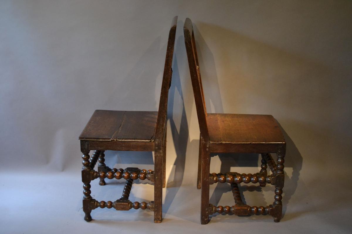 A rare pair of mid 17th century oak backstools