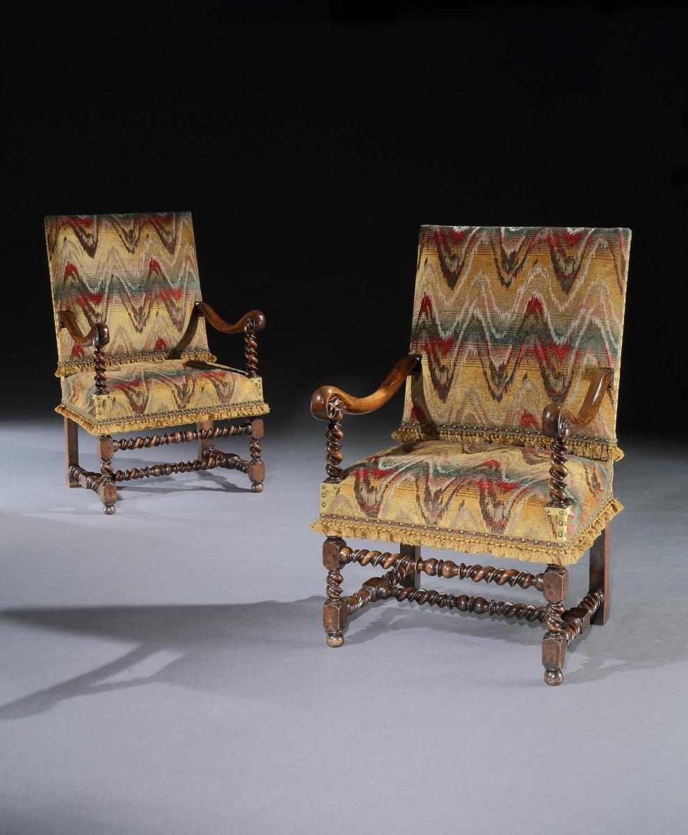 A pair of Flemish, mid-17th century, walnut, open armchairs upholstered in a re-created bargello with custom-made passmenterie