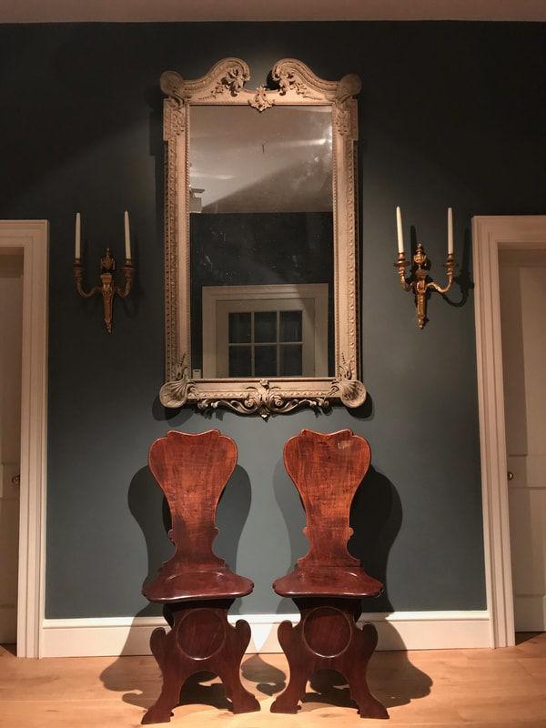 A fine pair of mahogany hall chairs of Scabello form with dished backs