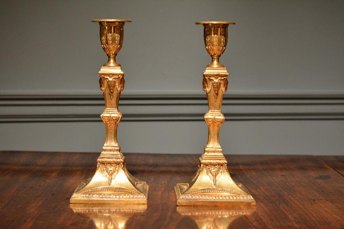  A fine pair of neo-classical ormulu candlesticks decorated overall with neo-classical motifs.