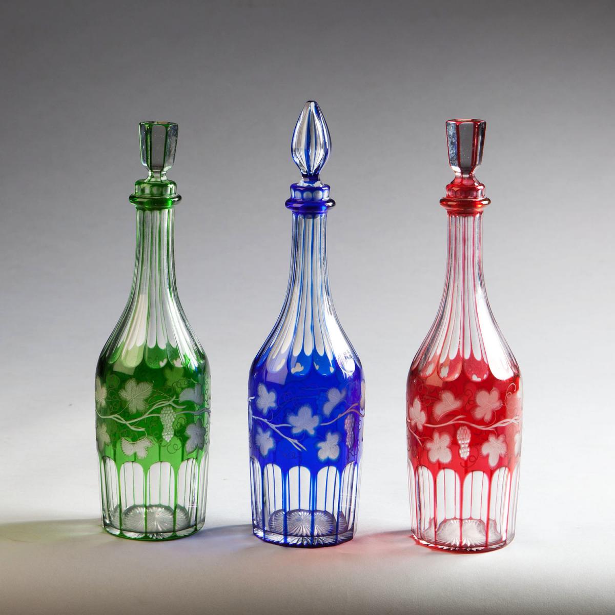A Set of Three Coloured Glass Bottles