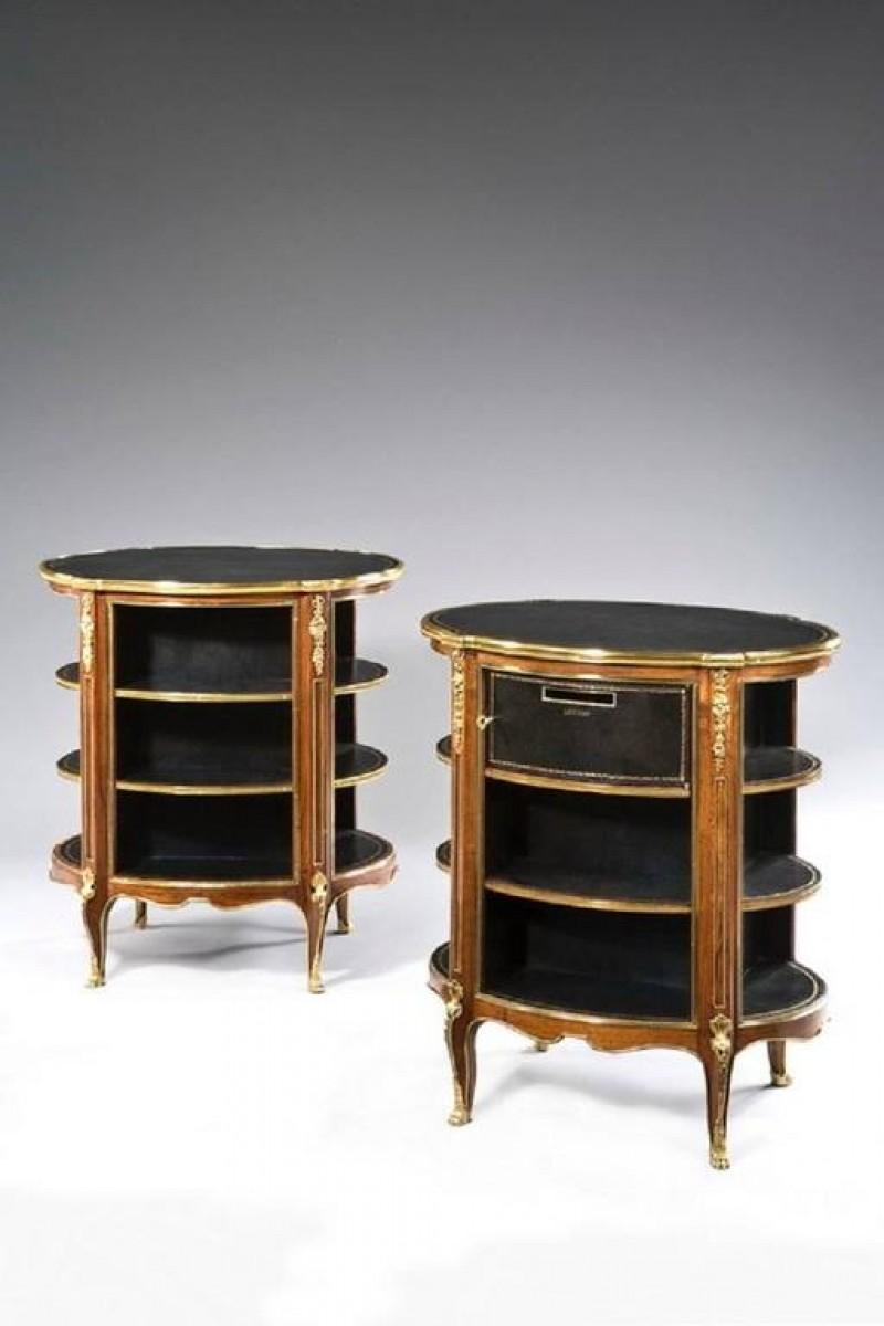 A Pair of Open Library Bookcases Inset with Oval Black Leather Tops
