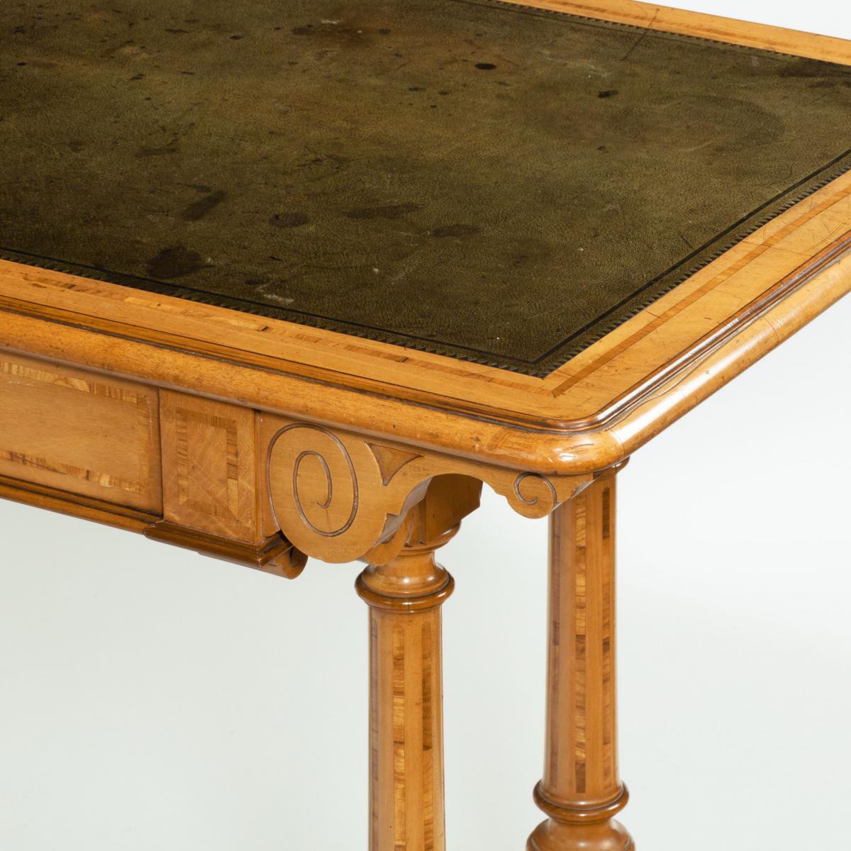 A Victorian birch or satinwood writing table, attributed to Holland and Sons