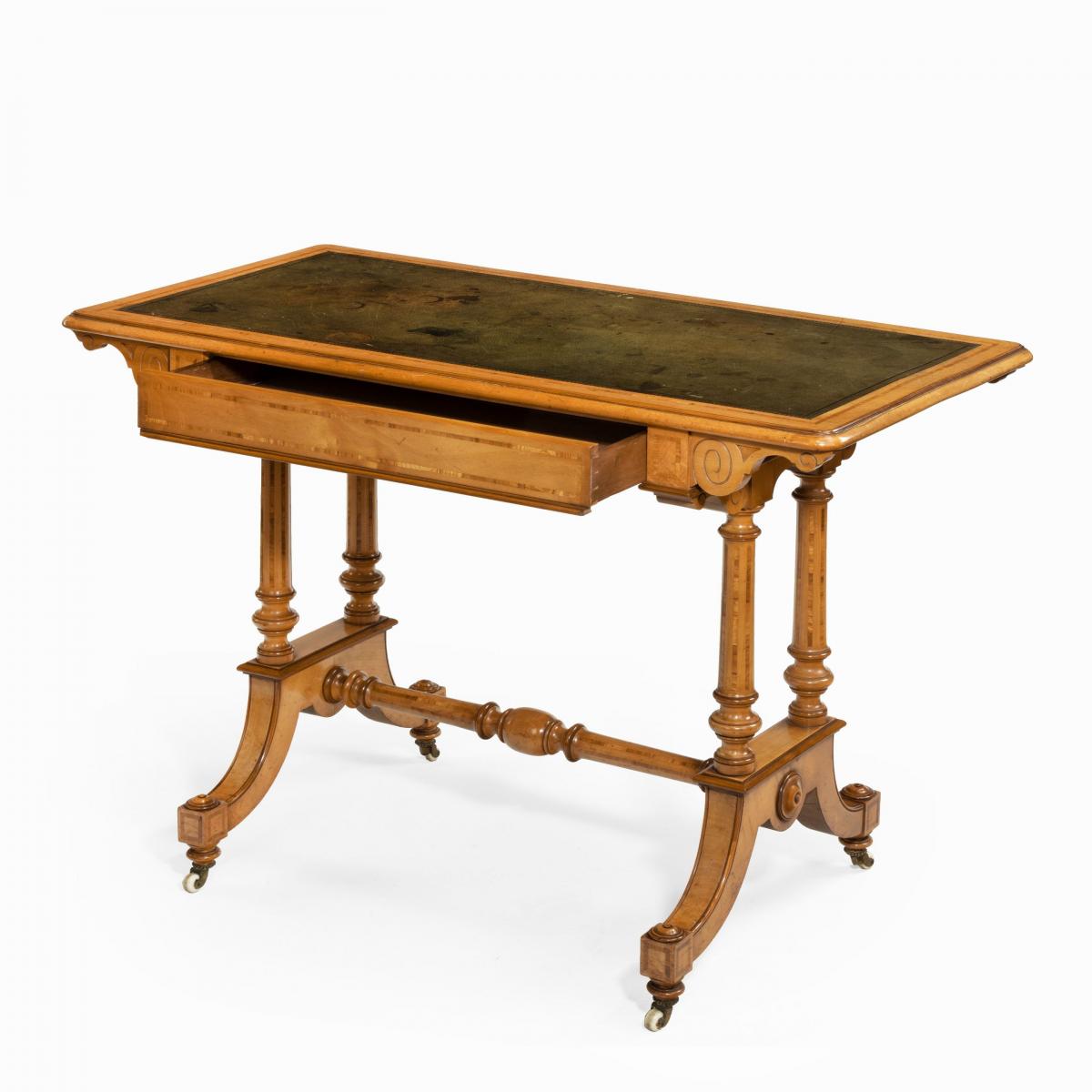 A Victorian birch or satinwood writing table, attributed to Holland and Sons