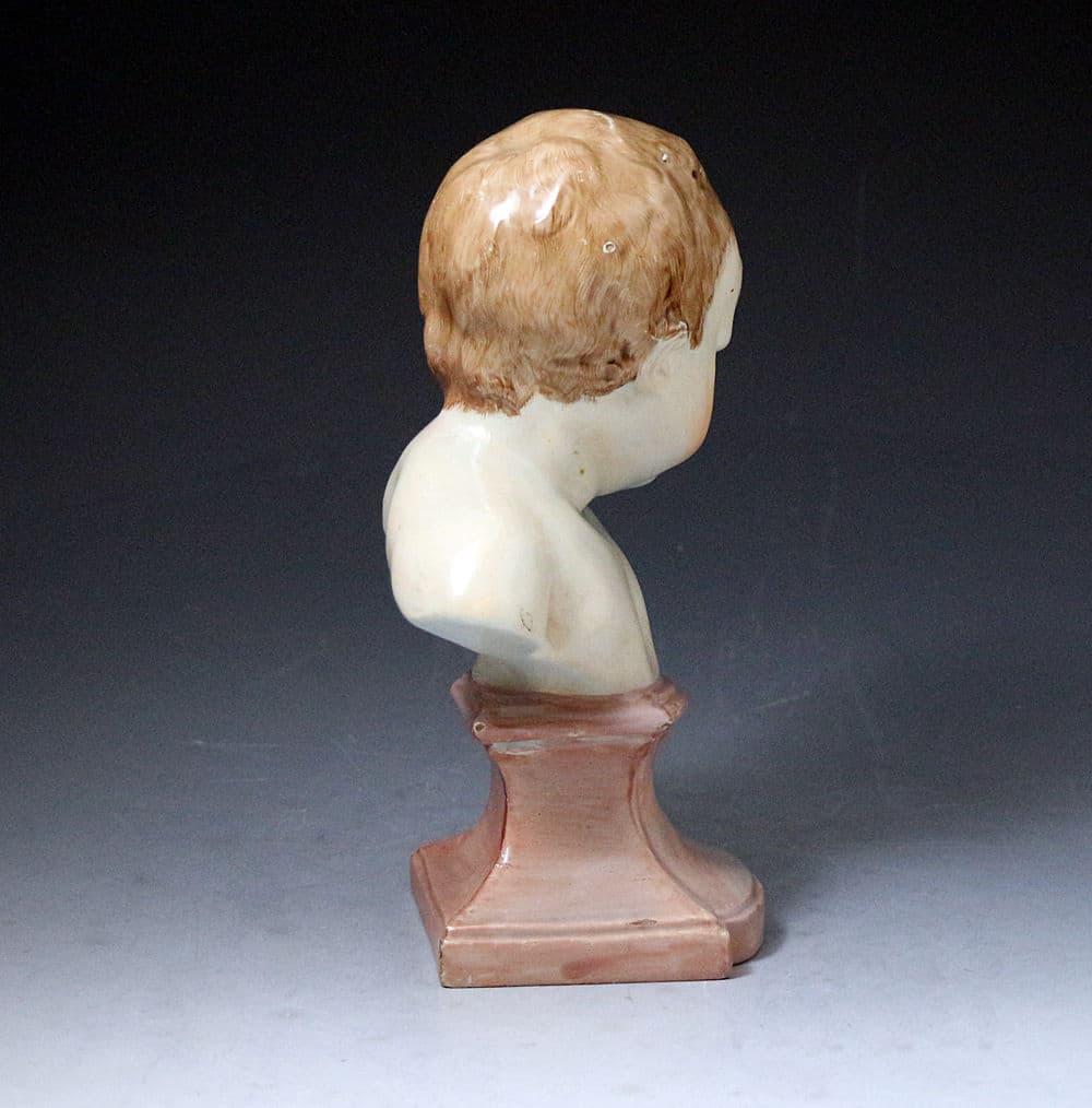 Staffordshire pearlware bust of a putto on a socle base, early 19th century