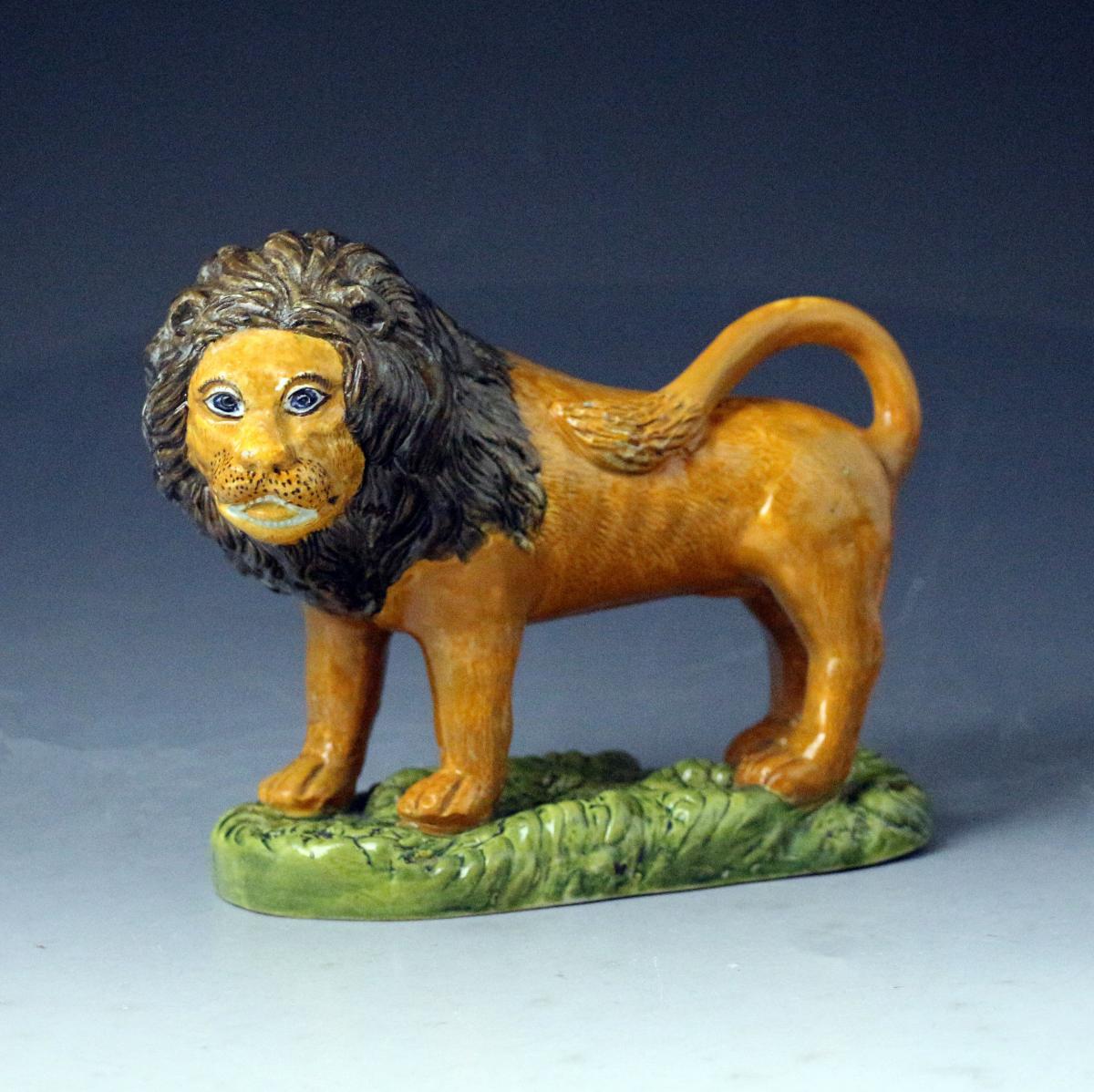 Prattware pottery figure of a standing Lion on a green grassy base, early 19th century