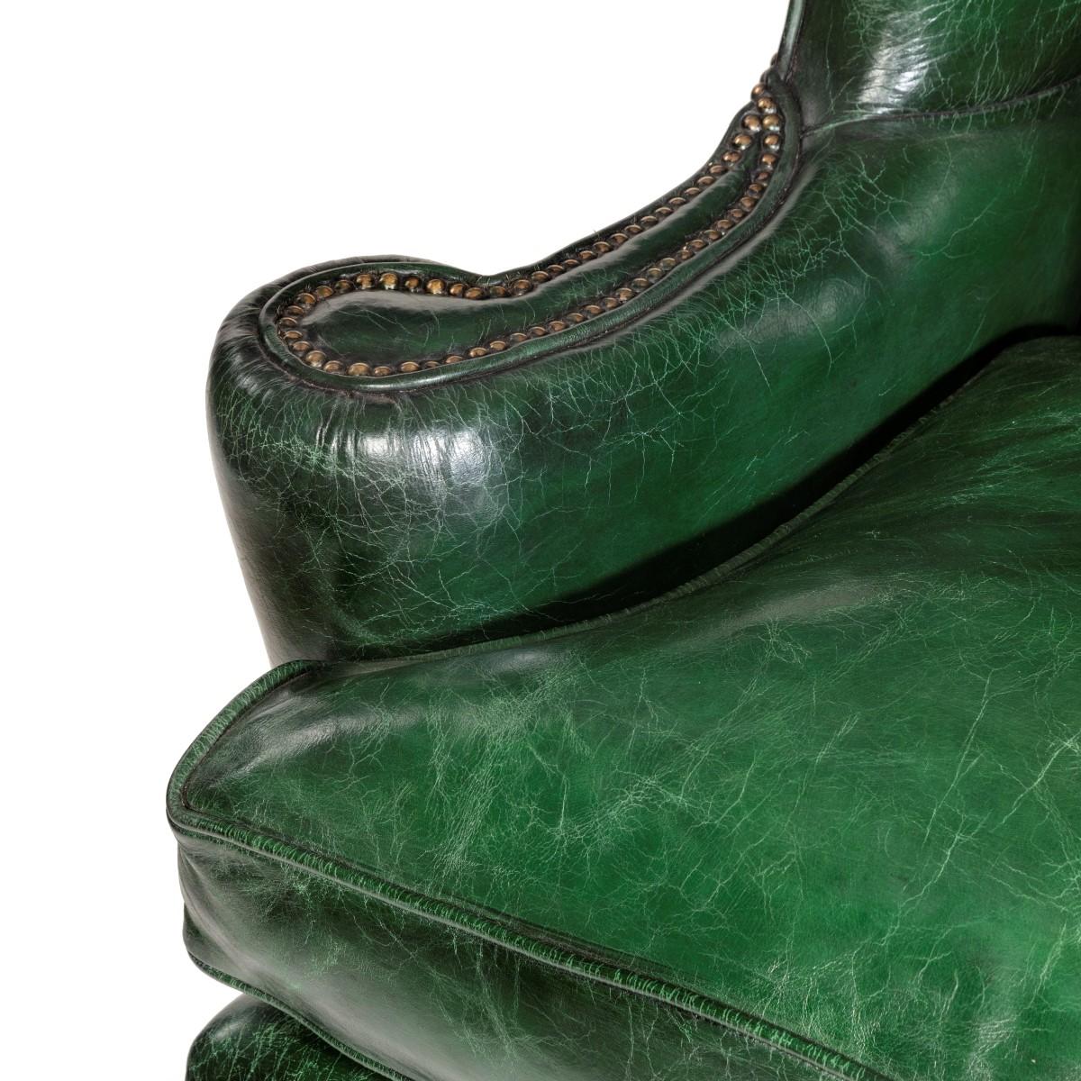 A George III style green leather wing arm chair