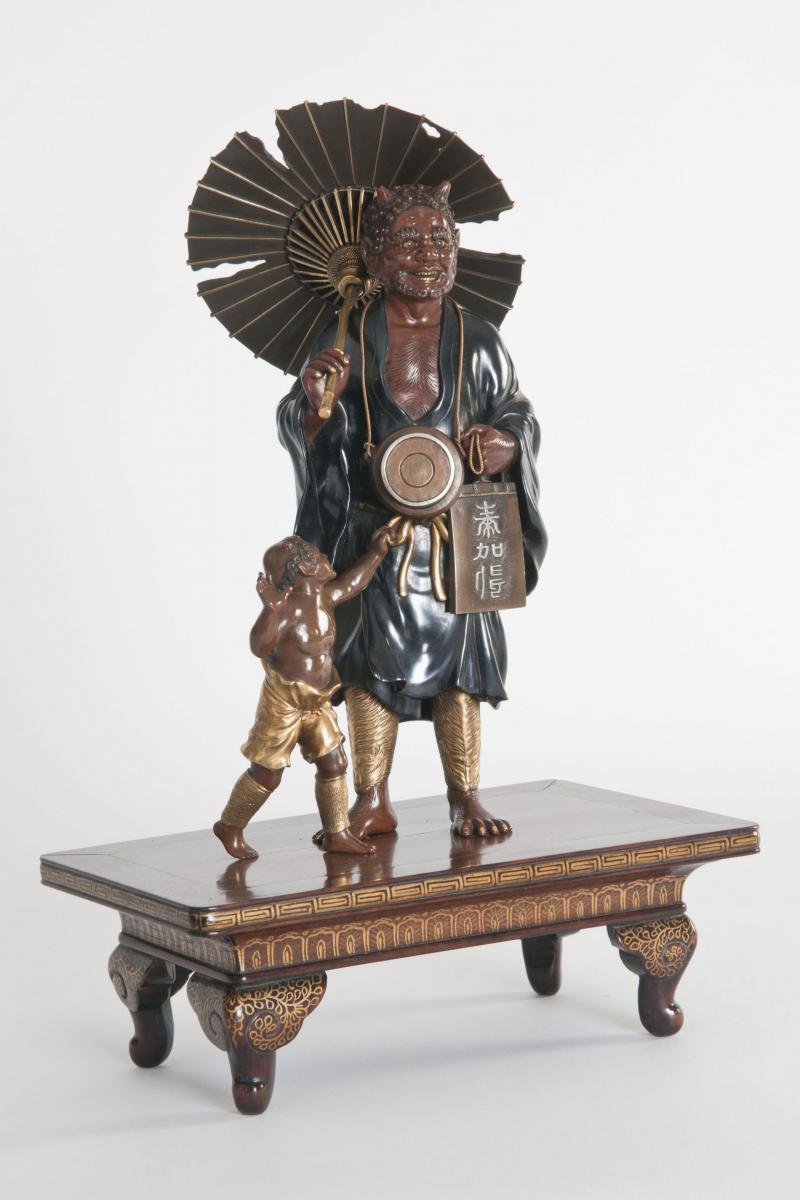 A meiji period bronze of an Oni holding a parasol