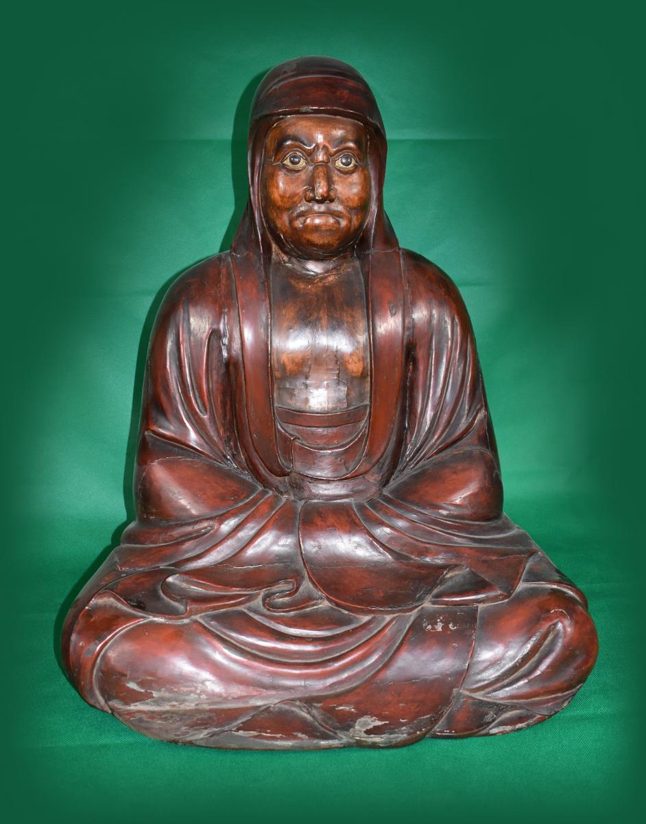 A seated Daruma carved from cyprus wood