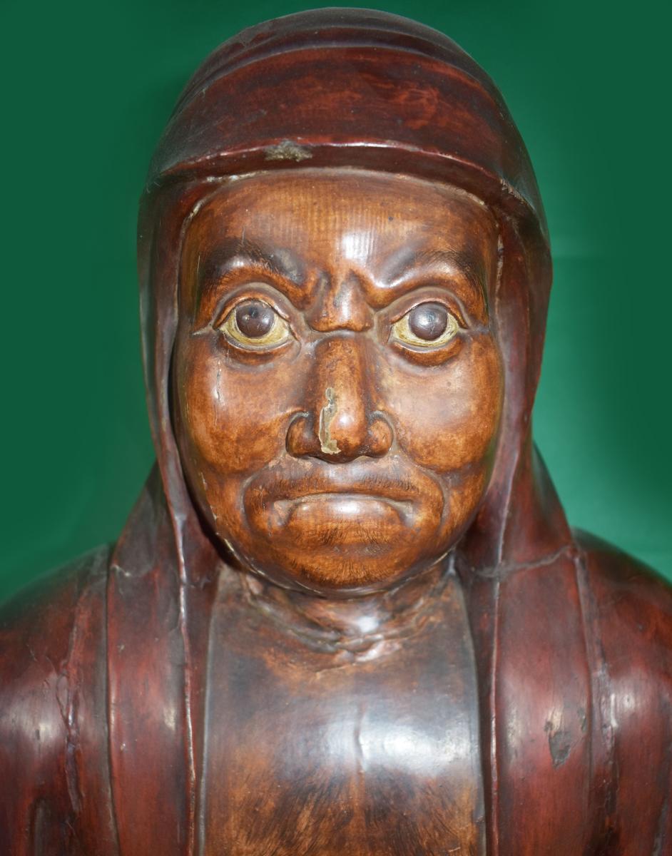 A seated Daruma carved from cyprus wood