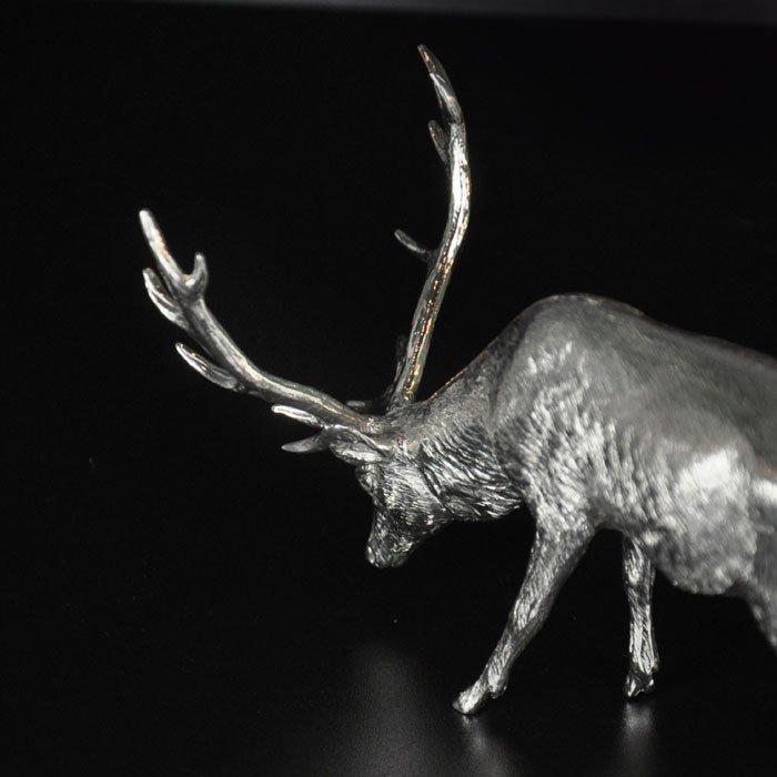 A sterling silver model of a grazing stag