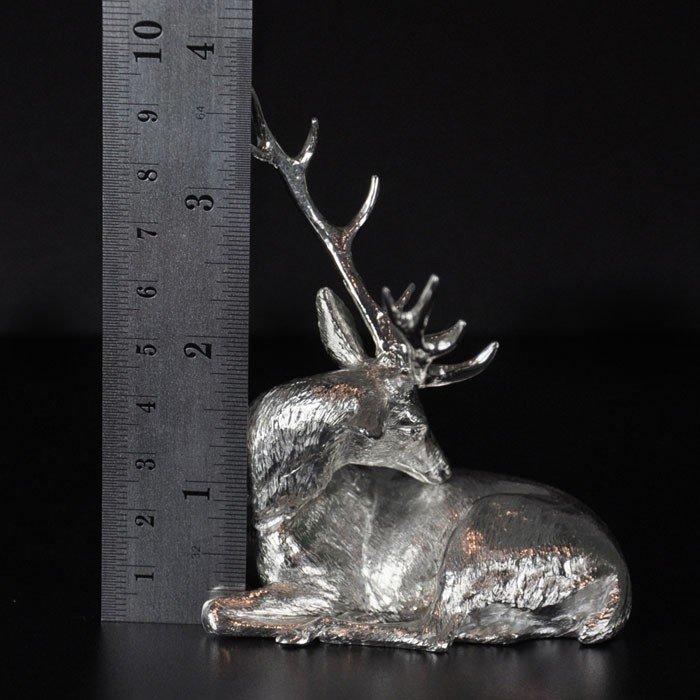 A sterling silver model of a grazing stag