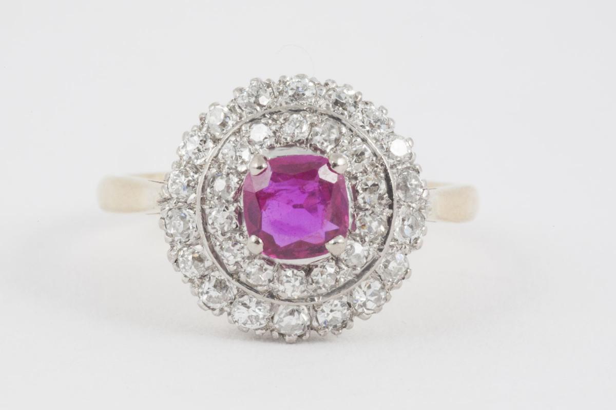 A circular shaped 1950’s vintage cluster ring with central Pink Burma ruby surrounded by two rows of brilliant cut diamonds set in 18 carat white and mounted in 18 carat yellow gold. UK ring size Q, USA ring size 8.5 1950’s Vintage piece in the Edwardian style. 20th century. English circa 1950. Central London based retailer.  Stock no. MA
