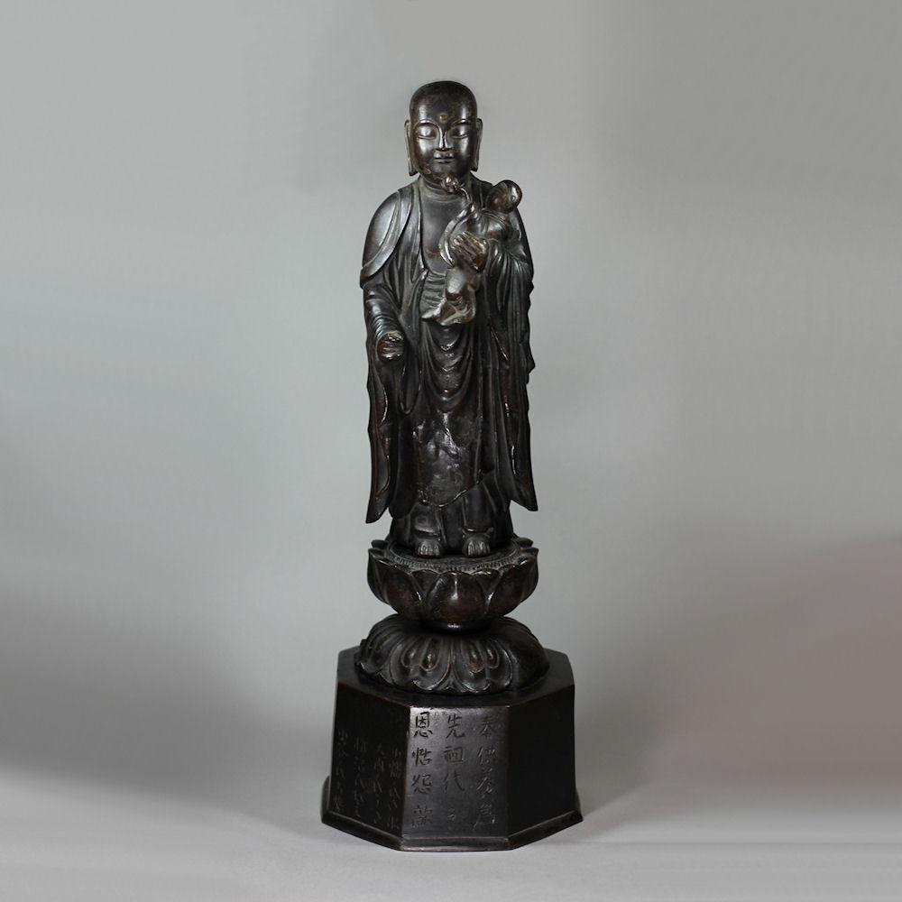 Rare Japanese bronze group of Buddha holding a child holding up a peach, late 18th century