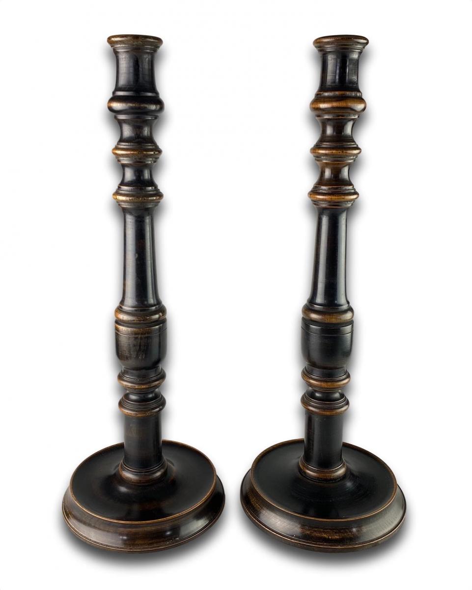 A large pair of ebonised walnut candlesticks. English, late 19th century