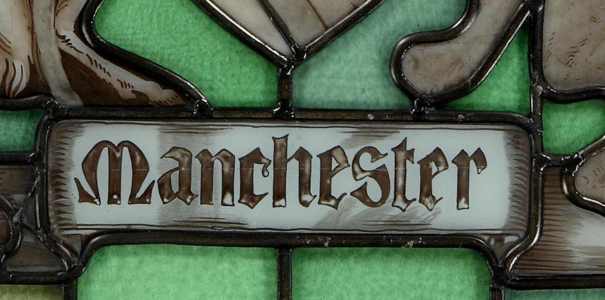 A stained & painted glass panel depicting the Coat of Arms of the City of Manchester