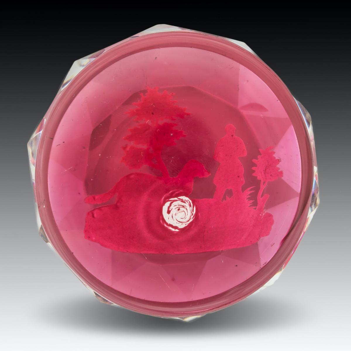 A Baccarat huntsman sulphide paperweight on translucent red ground