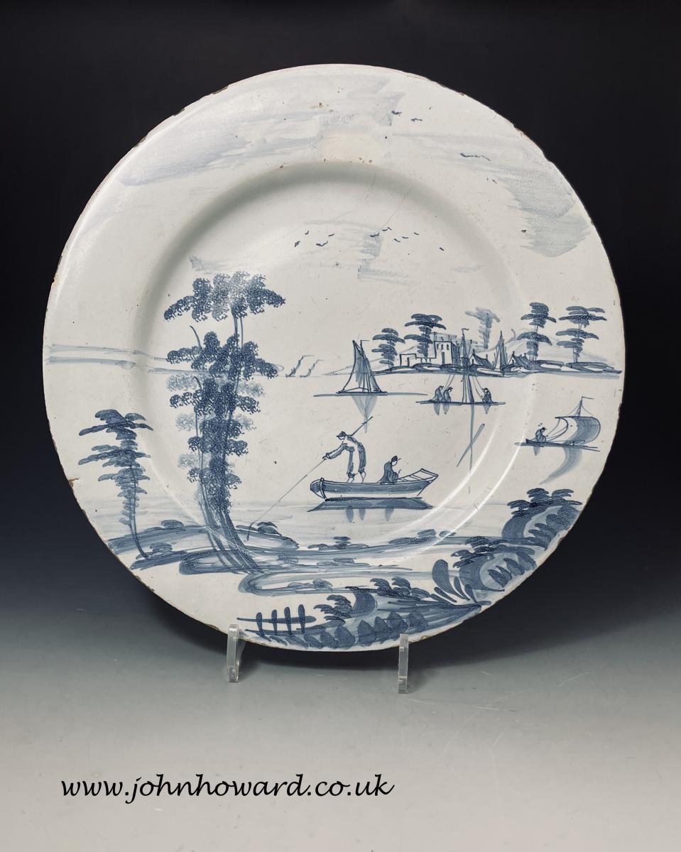 English delftware blue and white charger decorated with a romantic boating scene, Bristol 18th century