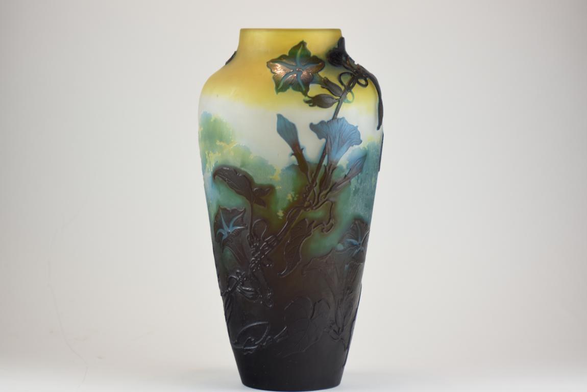 A large Galle vase decorated with convolvulus flowers and leaves in a woodland landscape