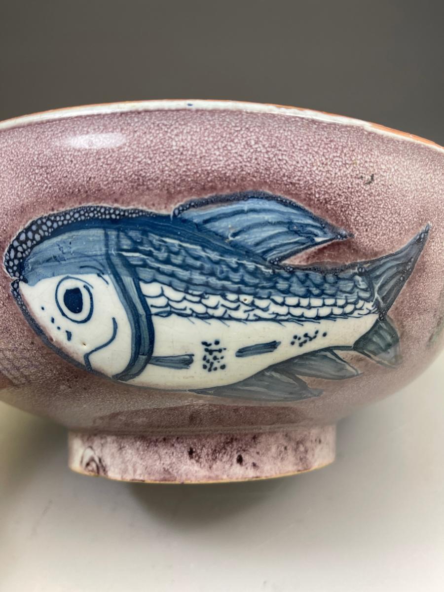 English delftware pottery bowl with manganese ground decorated with three blue fish 18th century