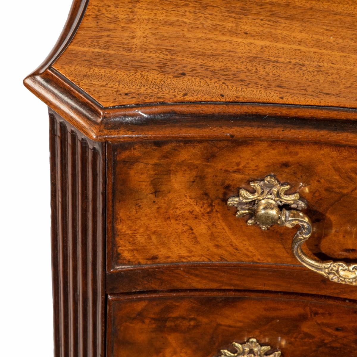 A flame mahogany George III serpentine chest of drawers