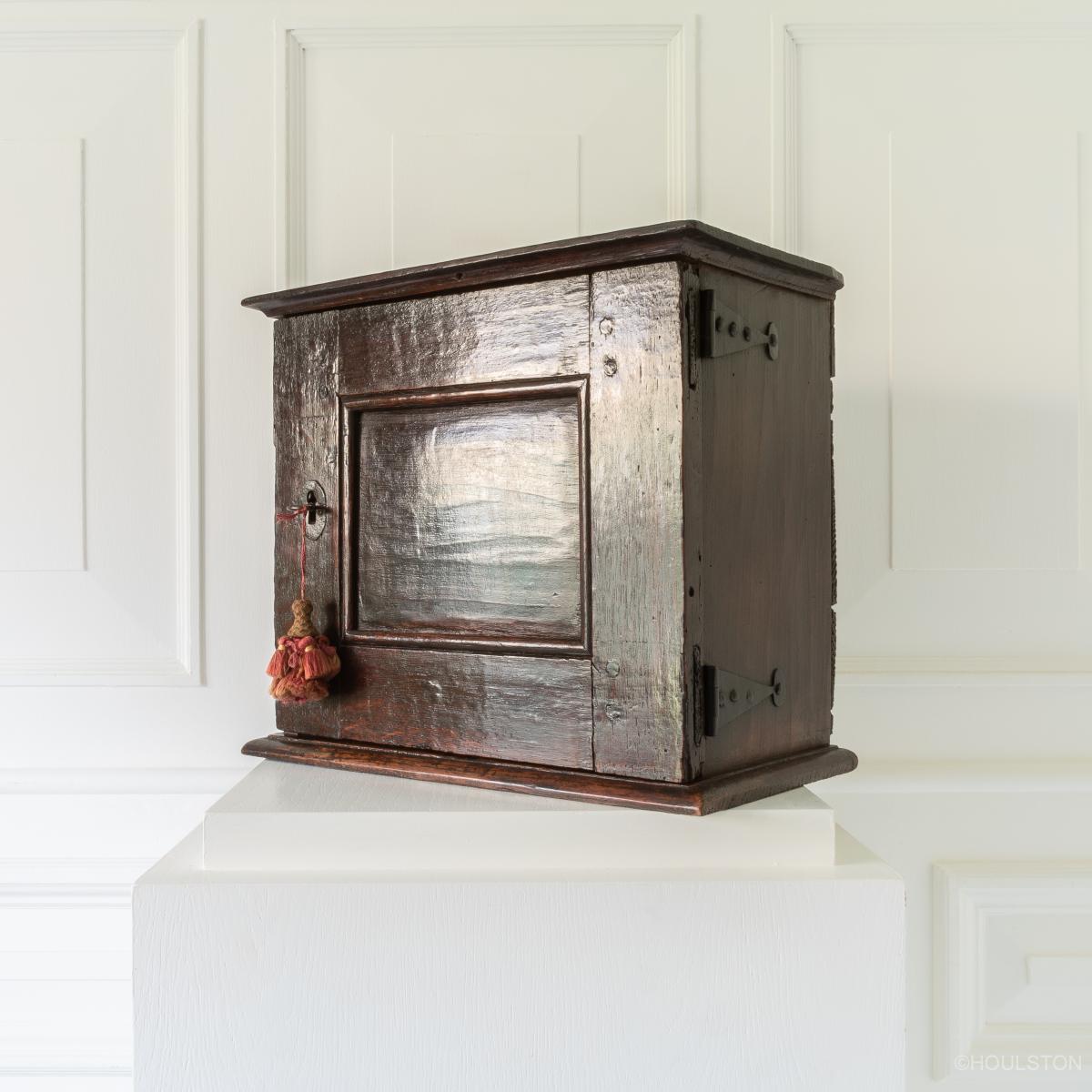 A small 17th century oak and elm spice cupboard