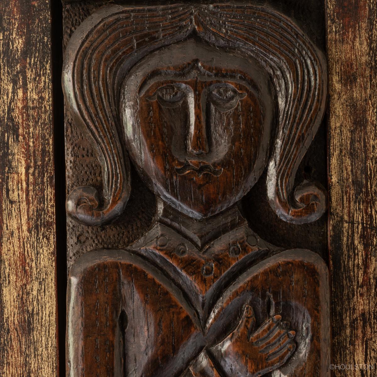 three 17th century carved oak figural terms in a frame