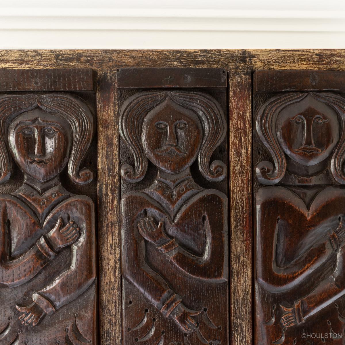 three 17th century carved oak figural terms in a frame
