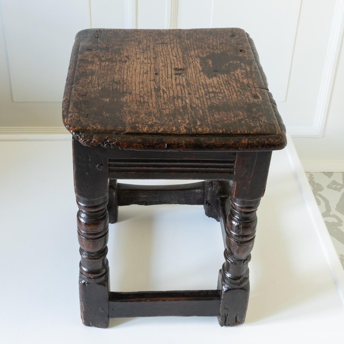 An early 17th century low oak stool