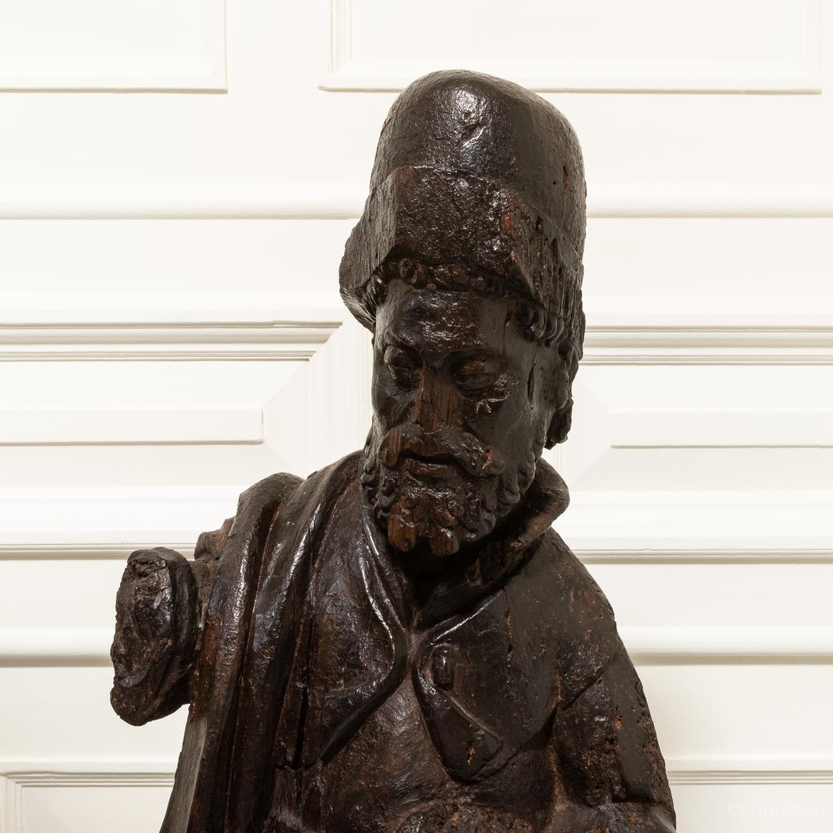 A 15th century carved oak sculpture of a pilgrim