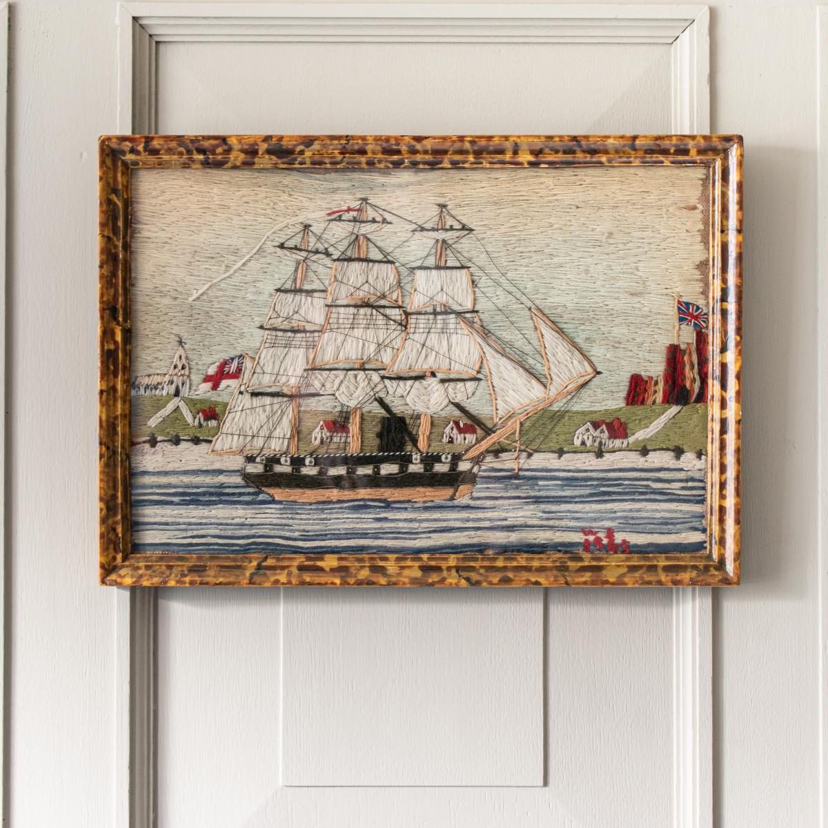 A 19th century wool embroidery of a ship in a painted frame