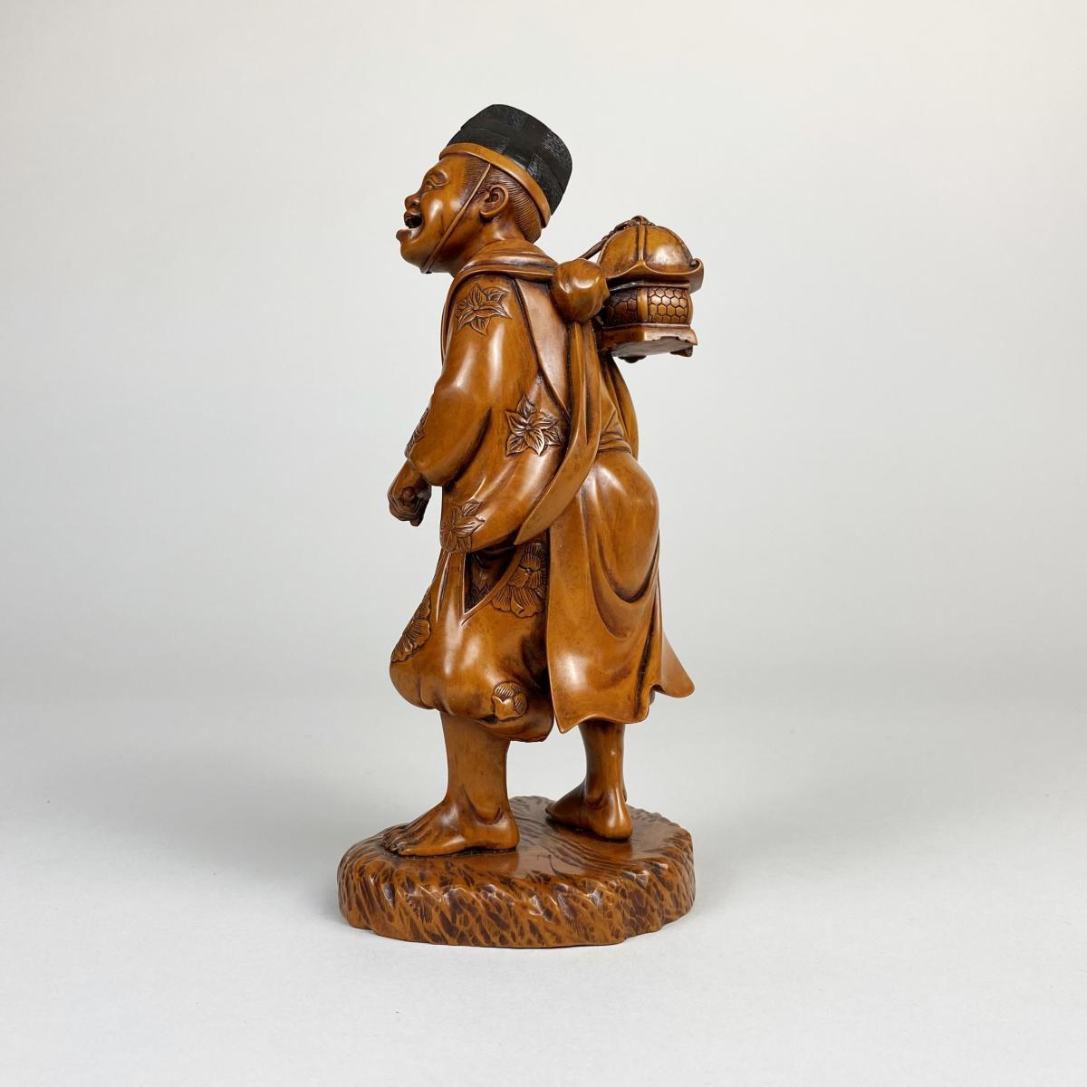 Wood carved Okimono depicting a man carrying a lantern | BADA