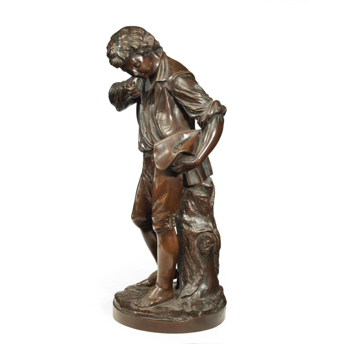A bronze study of a boy collecting fruit in his wide brimmed hat