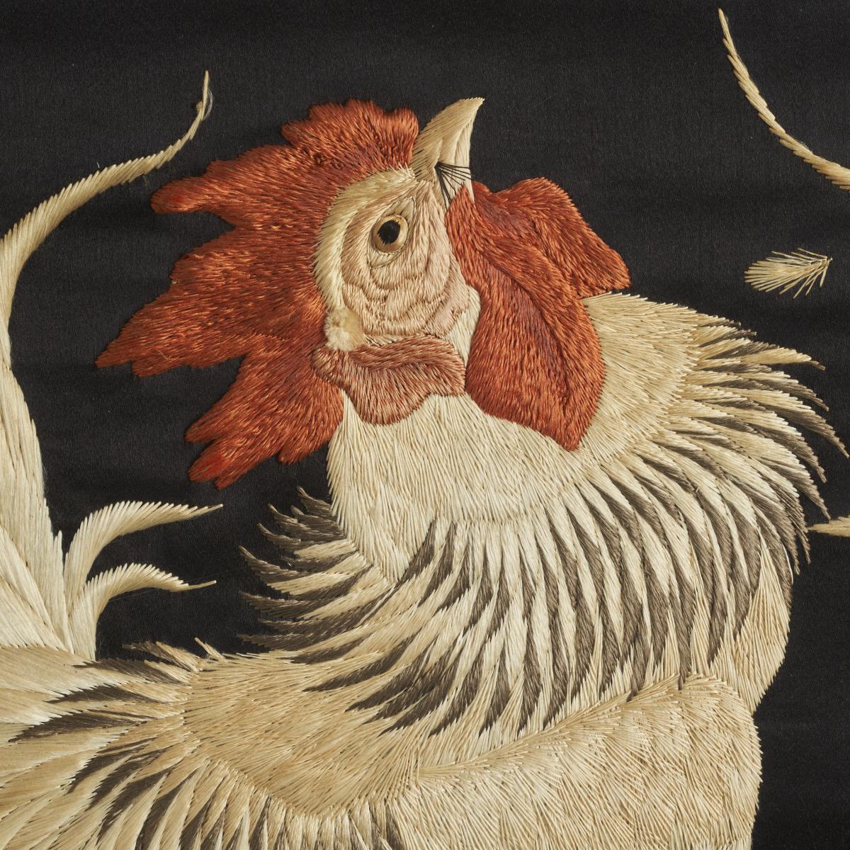 A dramatic silk embroidery depicting a pair of fighting Cockerels