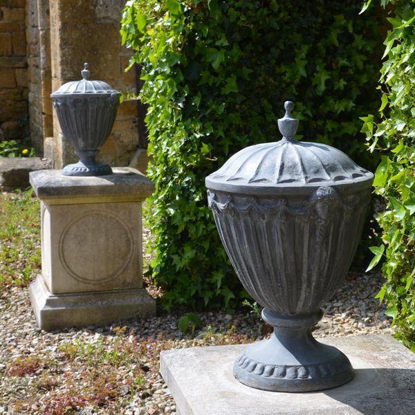 A pair of lead finial urns in the Adam style