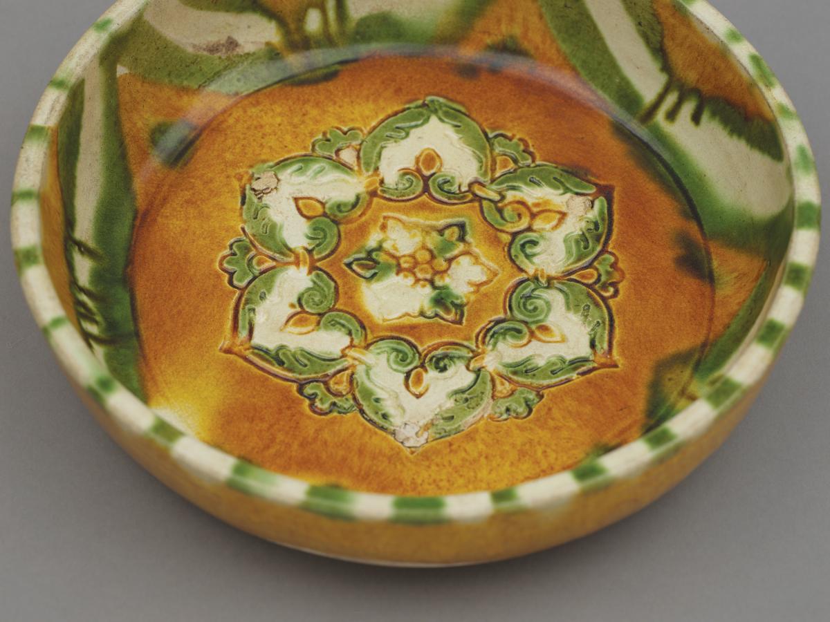 Chinese sancai, three-colour glazed pottery basin, pen, moulded in the centre with a six-petalled flowerhead, Tang dynasty, Gongxian kilns, 7th – 8th century.