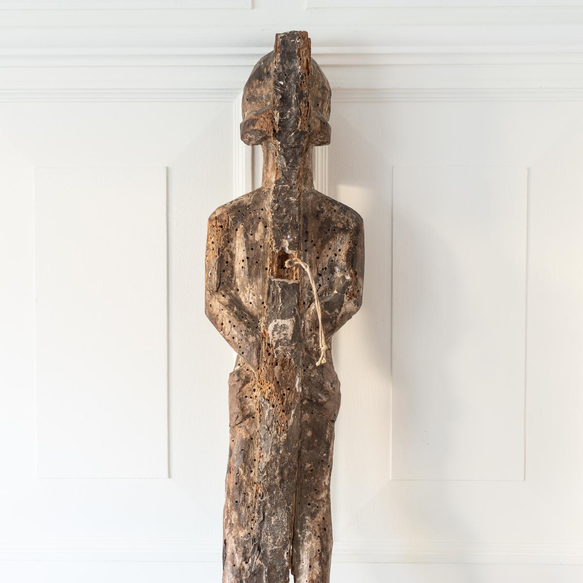 A partial and distressed carved oak figure of a saint - back view