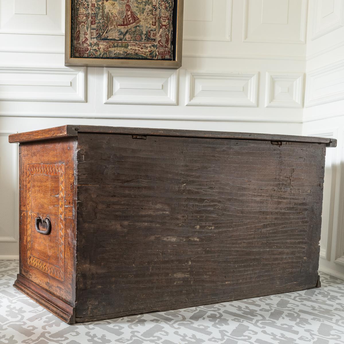 A large antique oak chest with architectural details and inlay, back view