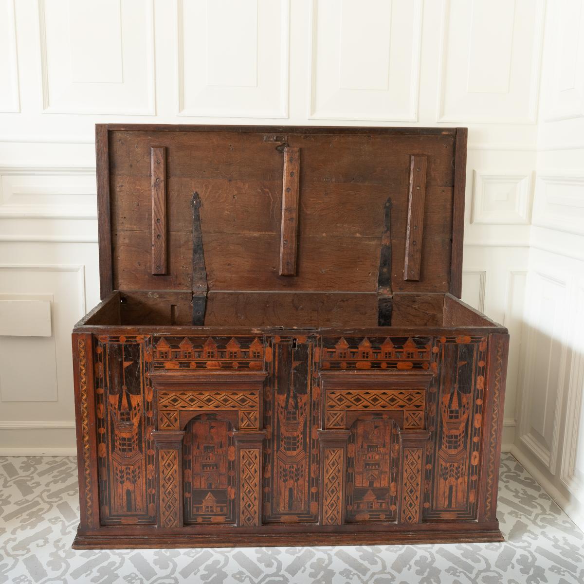 A large antique oak chest with architectural details and inlay, top open