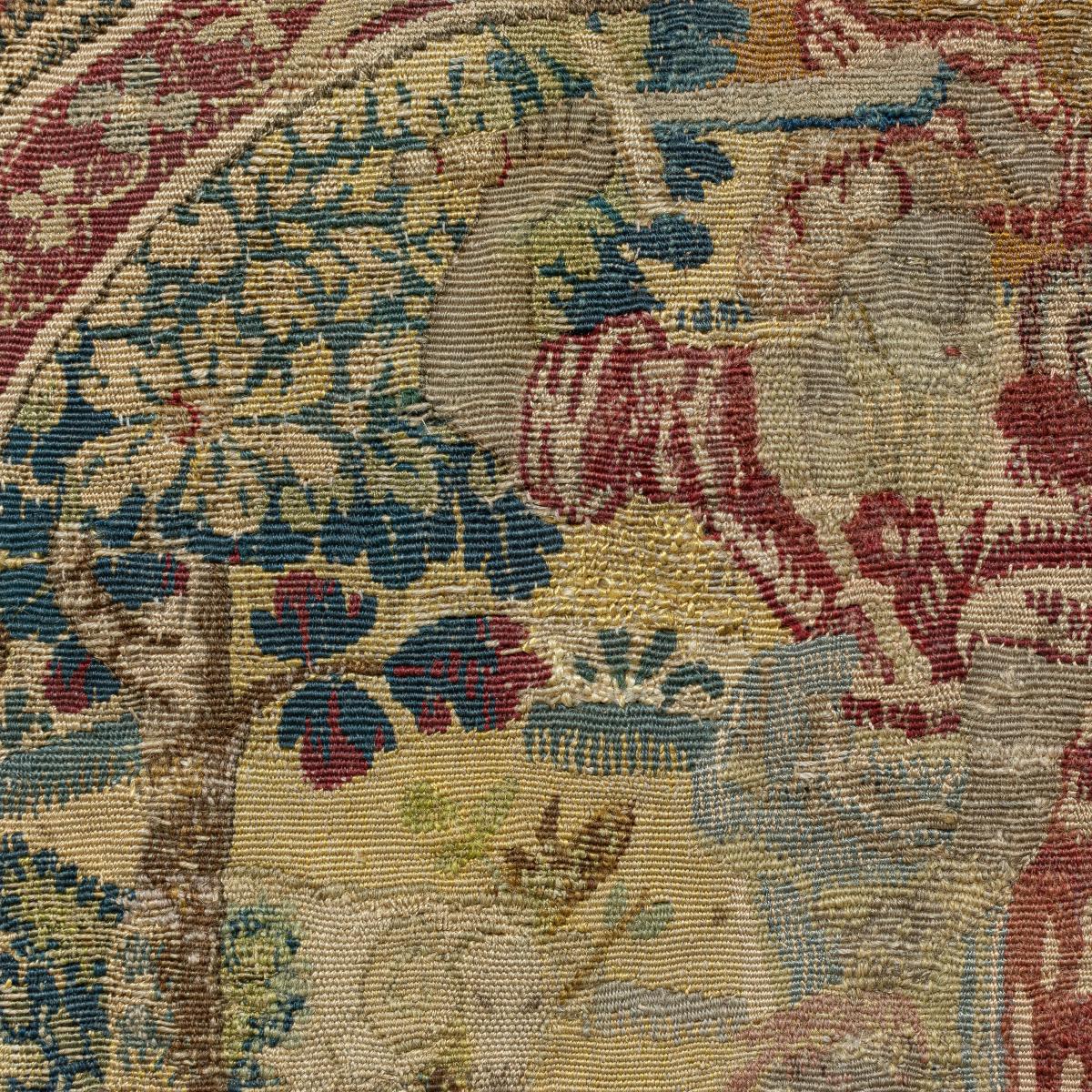 An antique tapestry cushion cover in a frame