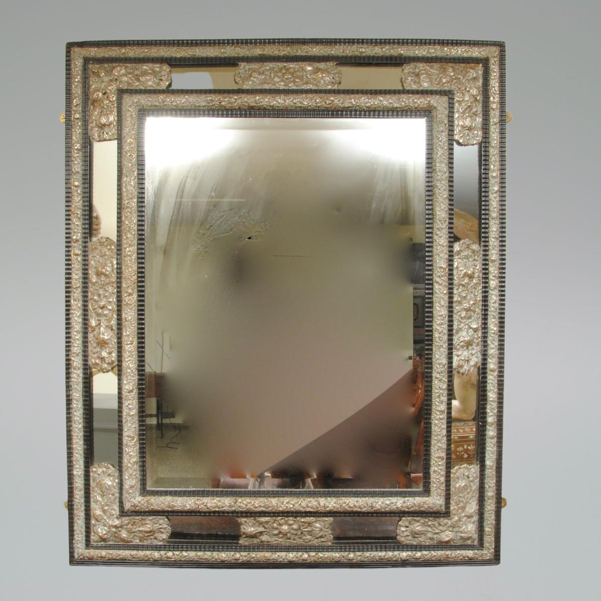 A Large Flemish Ebonised Ripple Cushion Mirror with Silvered Repousse Decoration