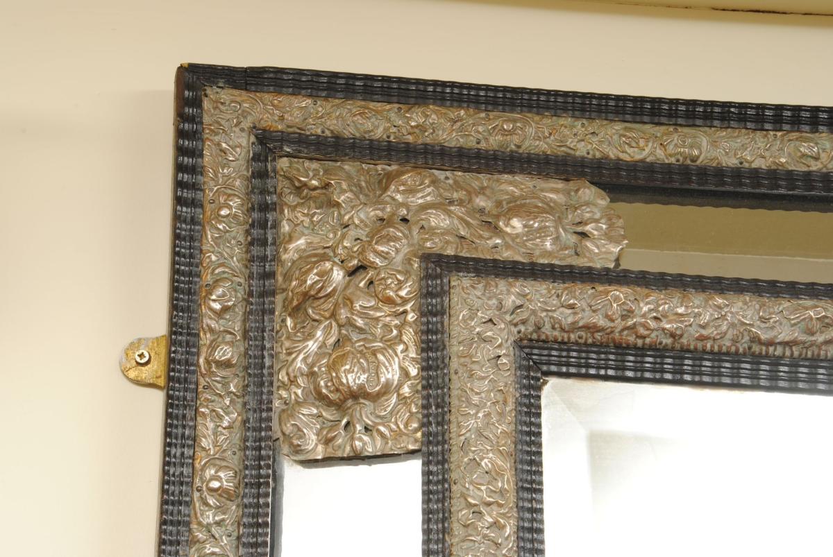 A Large Flemish Ebonised Ripple Cushion Mirror with Silvered Repousse Decoration