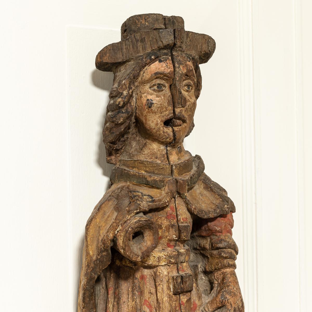 A close up of the top half of a 16th century carved figure
