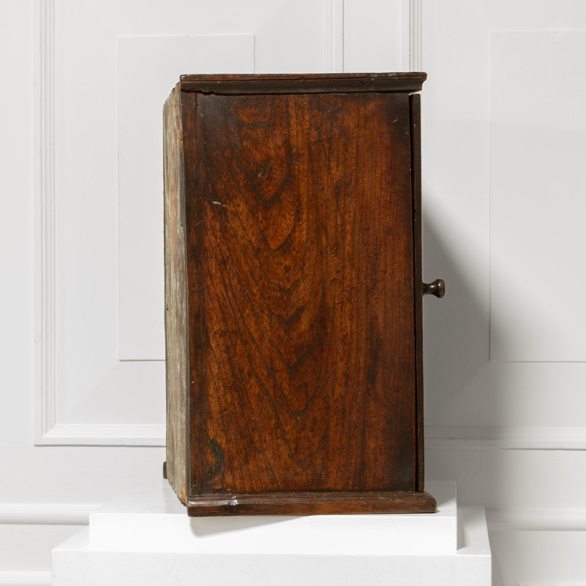 An early 18th century fruitwood and elm table-top spice cupboard, English or Welsh, circa 1700-20