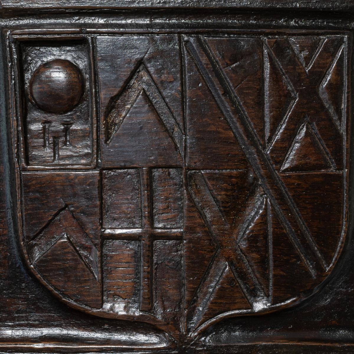 A Henry VIII carved oak and polychrome armorial panel, probably representing a marriage, circa 1520