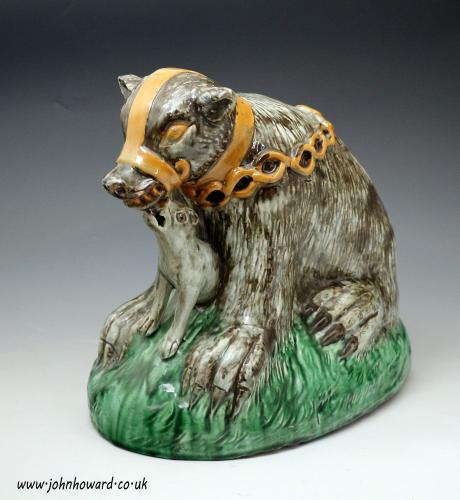 Large scale pottery figure of a bear baited by a dog, late 18th century Staffordshire England