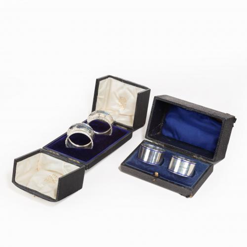 Two boxed pairs of silver napkin rings
