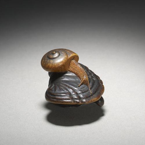 Wood netsuke of a snail on fungus. Circa 1870 by Shigemasa