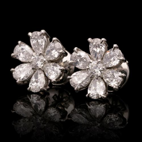 A beautiful pair of platinum and pear-shaped diamond flower head earrings